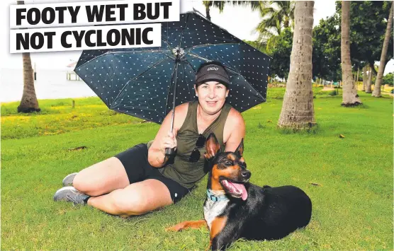  ??  ?? BROLLY NICE DAY: North Ward resident Belinda Johnston, with dog Mickey, enjoys the drizzly conditions at the Strand.
