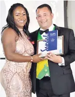  ??  ?? Kadeen is all smiles as she collects her award for Team Member of the Year from Sandals Montego Bay’s general manager, Carl Beviere.