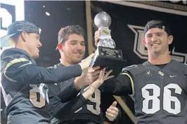  ??  ?? The Knights are proud to show off the national championsh­ip trophy they received at Monday’s event from Glenn Cunningham of Reddit College Football.