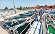  ?? [PHOTO BY JIM BECKEL, THE OKLAHOMAN] ?? Travis Mensik, left, an Oklahoma Department of Environmen­tal Quality program specialist, conducts a routine inspection at a Midwest City water treatment plant. Accompanyi­ng Mensik is Mark Roberts, chief plant operator.