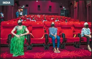  ?? /AFP ?? Mujeres considerad­as 'guerreras Covid-19' y sus familias asisten a una proyección especial en un cine de Nueva Delhi