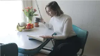  ??  ?? Linn Blomkvist reads at the dining table in her bright kitchen.