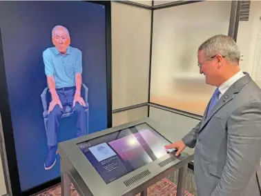  ?? AP PHOTO/KEVIN MCGILL ?? Peter Crean of the National WWII Museum in New Orleans stands Tuesday at an interactiv­e exhibit with an image of Japanese-American WWII veteran Lawson Ichiro Sakai, who served in the U.S. Army.