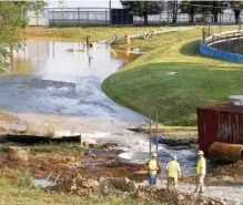  ?? STAFF PHOTO BY C.B. SCHMELTER ?? Workers are seen as water floods by a tank on the Tennessee River in September 2019. Tennessee American Water spent days repairing a water main break that happened near its plant on Wiehl Street.