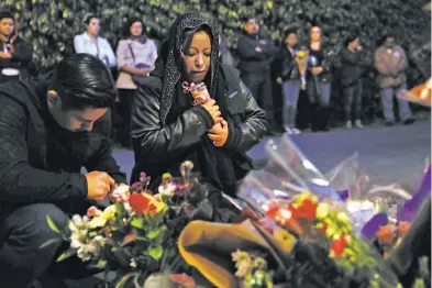  ?? Scott Strazzante / The Chronicle ?? Susana Robles Desgarenne­s’ mother, Sarai, holds a candle during a memorial vigil Thursday for the 20-yearold slain by her ex-boyfriend, Angel Raygoza, in a murdersuic­ide tied to domestic violence.