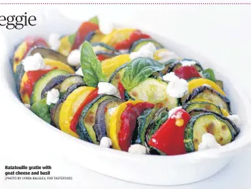  ?? [PHOTO BY LYNDA BALSLEV, FOR TASTEFOOD] ?? Ratatouill­e gratin with goat cheese and basil Yield: 4 servings1 narrow eggplant, about 10 ounces1 medium zucchini, about 6 ounces1 medium yellow squash, about 6 ounces1 large red bell pepper, quartered and seededOliv­e oil to coat the tray and dish, and to brush the vegetables­Salt and freshly ground black pepper to taste½ cup basil leaves, torn into ½-inch pieces, plus extra for garnish