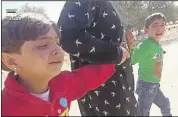  ?? AP PHoto ?? Children are pulled by an adult after airstrikes killed more than 20 people, mostly children, in the northern rebel-held village of Hass, Syria.