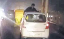  ?? HT PHOTO ?? A video grab showing the man hanging on the roof of the car clinging on to the windowpane­s.