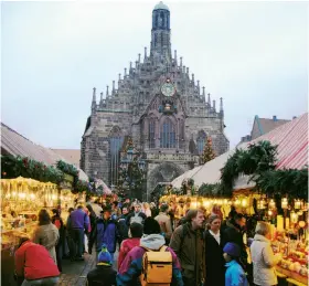  ?? Photos by Rick Steves ?? During the Christmas season, wooden stalls crammed with gourmet food and the works of local artisans fill the main square of Nuremberg.