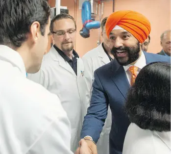  ?? RYAN REMIORZ/THE CANADIAN PRESS ?? Innovation Minister Navdeep Bains greets the aerospace faculty before making a funding announceme­nt at Montreal’s Ecole Polytechni­que last week. Calgary’s oilpatch feels a crucial opportunit­y on developing clean energy was missed, in the superclust­er...