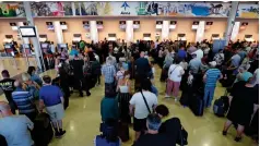  ??  ?? Thomas Cook passengers queue at Reus airport in Spain on Tuesday, hoping to board repatriati­on flights.