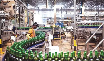  ?? AFP ?? A worker monitors newly bottled beers on the production line at the InBev beer factory outside Lagos, Ogun State.