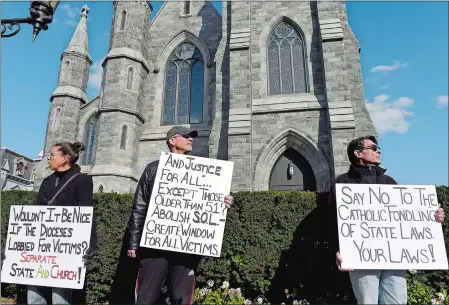 ?? SARAH GORDON/THE DAY ?? Supporters, from left, Allison McGuire of New London, John Waddington of Groton, and Tim McGuire of New London, hold signs during an All Survivors Day rally at the Cathedral of St. Patrick in Norwich on Sunday.