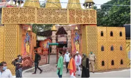  ?? — PTI ?? People move past the Ram Janmabhoom­i Nyas workshop ahead of the ground breaking ceremony of the Ram Mandir in Ayodhya on Monday.