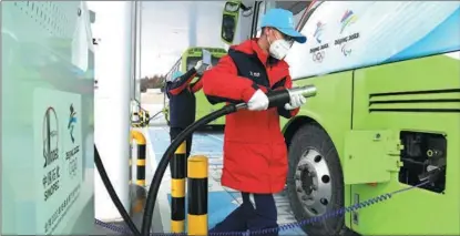  ?? HU QINGMING / FOR CHINA DAILY ?? A Sinopec employee charges an electric bus at a green hydrogen filling station in Beijing in January.