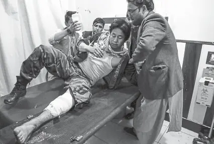  ?? AFP via Getty Images ?? A wounded man receives treatment in a hospital after a suicide bomber blew himself up in an education center in Kabul on Saturday. The attack killed at least 18 people.
