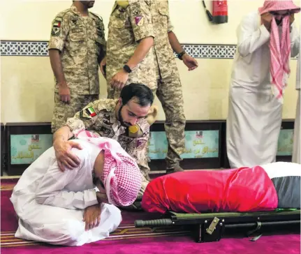  ?? Antonie Robertson / The National ?? A mourner is comforted during the funeral service in Dubai for Saif Al Falasi, below.