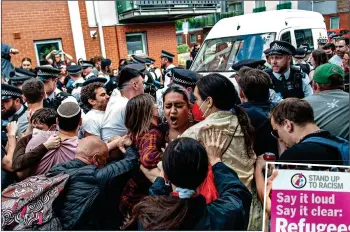  ?? ?? SCUFFLE: Protesters block the police van yesterday and right, a placard