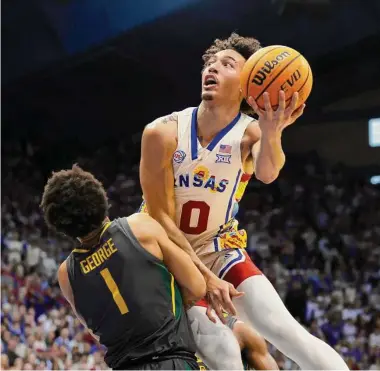  ?? Colin E. Braley/Associated Press ?? Kansas forward Jalen Wilson, top, is fouled by Baylor guard Keyonte George during the first half of Saturday’s game at Lawrence, Kan. The Jayhawks overcame a 15-point deficit to beat the Bears 87-71.