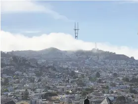  ?? Photos by Carl Nolte / The Chronicle ?? A bank of fog rolls in on Twin Peaks above Noe Valley, as seen from Bernal Heights. But it’s not thick enough to hide all of the 977foottal­l Sutro Tower.