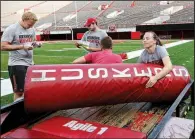  ?? AP/NATI HARNIK ?? Nebraska student manager Kelli Leachman carries a goal post pad as she and other managers prepare for a Cornhusker­s practice.