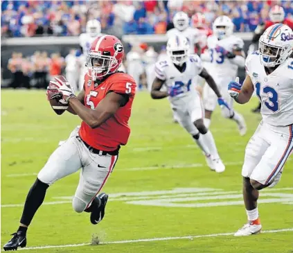  ?? JOHN RAOUX/AP ?? Georgia’s Terry Godwin, left, catches a 24-yard touchdown pass past Florida safety Donovan Stiner, right, during the second half Saturday.