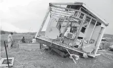  ??  ?? Juan Negron, right, prepares to start up a power generator in front of what’s left of his property on the island of Culebra, Puerto Rico.