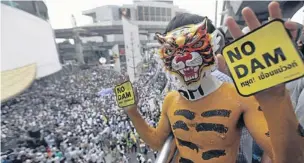  ?? THITI WANNAMONTH­A ?? An activist wearing a tiger mask campaigns against the Mae Wong dam project in the Mae Wong National Park in Nakhon Sawan province. Thousands of dam opponents gathered at the Bangkok Art & Culture Centre at Pathumwan intersecti­on yesterday as the Seub...