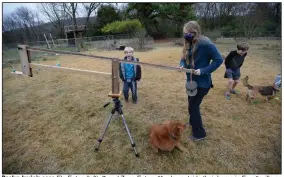  ?? (NWA Democrat-Gazette/Andy Shupe) ?? Roslyn Imrie’s sons Elo Eaton (left), 7, and Zane Eaton, 11, play outside their home in Fayettevil­le as Imrie reposition­s a boom that her husband made to steady a pair of binoculars so the whole family can view things in the night sky. Zane and Elo are both on the autism spectrum, which complicate­s their learning from home.