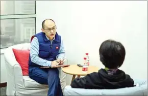  ?? AFP ?? Marriage counsellor Zhu Shenyong (left) advises a client in Shanghai on March 7.