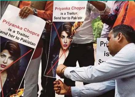  ?? REUTERS PIC ?? Supporters of Hindu Sena, a right wing Hindu group, burning posters of Bollywood actress Priyanka Chopra during a protest in New Delhi, India, on Saturday.