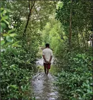  ?? ?? Aslori walks Sept. 5 on a flooded village pathway in Mondoliko.