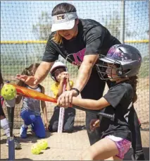  ?? VINCENT OSUNA PHOTO ?? Imperial Valley College softball player Cristina Garcia teaches Hailey Lepe how to perform a batting drill during IVC’s softball clinic on Saturday morning in Imperial.