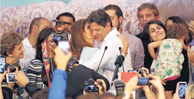  ?? JF DIORIO / ESTADÃO ?? Discurso. O candidato derrotado do PT, Fernando Haddad, é beijado pela mulher, Ana Estela, após fazer pronunciam­ento em São Paulo admitindo a derrota para Jair Bolsonaro, do PSL