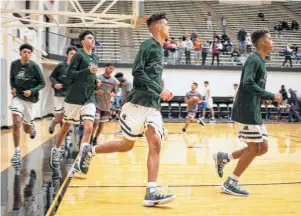  ?? Photos by Matthew Busch / Contributo­r ?? Reagan senior Kaeyel Moore, center, runs warmup drills as he returns to the basketball court for a Rattlers game for the first time since he suffered cardiac arrest in early January.