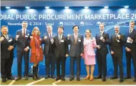  ?? Courtesy of PPS ?? Public Procuremen­t Service (PPS) Administra­tor Jung Moo-kyung, fifth from left, his Romanian counterpar­t Bogdan Puscas, fourth from left, and Korea Trade-Investment Promotion Agency (KOTRA) CEO Kwon Pyung-oh, fifth from right, raise their fists with other officials at the Global Public Procuremen­t Marketplac­e 2019, held in the Interconti­nental Seoul COEX in Samseong, southern Seoul, Wednesday.