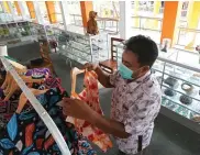  ??  ?? PERLUAS PASAR: Anggit Permana menata produk pelaku UKM di Kota Pahlawan yang dititipkan di Surabaya Square, Sentra Ikan Bulak (SIB), kemarin.