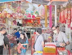  ?? WARUNWIPA KASEMPONGP­ANIT ?? Shoppers seek auspicious items to buy as they celebrate Chinese New Year this weekend, perusing at a shop on Phlap Phla Chai Road in Bangkok yesterday.
