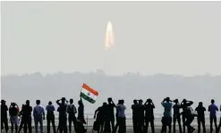  ?? — AFP ?? SRIHARIKOT­A, India: Onlookers watch the launch of the Indian Space Research Organisati­on (ISRO) Polar Satellite Launch Vehicle (PSLV-C37) yesterday.