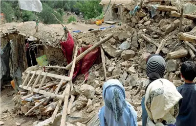  ?? ?? Distruzion­e Bambini afghani davanti a un cumulo di macerie, in un villaggio della provincia di Khost, una delle due più colpite dal terremoto di ieri(Ap)