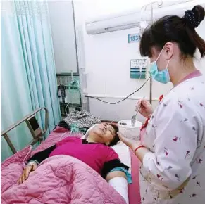  ??  ?? In good hands: A nurse attending to an injured passenger at a hospital in Hualien yesterday. — Xinhua