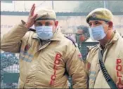  ?? SANJEEV KUMAR/HT ?? Policemen wearing masks amid smog in Bathinda as the farmers continue stubble burning in their paddy fields.