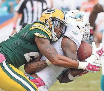  ?? JIM MATTHEWS / USA TODAY NETWORK - WISCONSIN ?? Green Bay Packers safety Ha Ha Clinton-Dix lays a hit on receiver Mike Wallace knocking the ball loose against the Miami Dolphins at Sun Life Stadium.