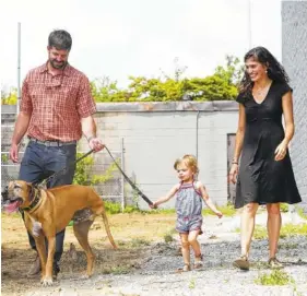  ?? STAFF PHOTO BY ERIN O. SMITH ?? Bob, Adeline and Caroline Poore walk with their dog Bode Wednesday at the Play.Wash.Pint location in Chattanoog­a.