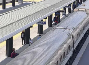  ?? Will Waldron / Times Union ?? Amtrak Lake Shore Limited rail service passengers wait for departure on Monday at the Albany-rensselaer station in Rensselaer. Amtrak is cutting back on long-distance trains to three days a week.