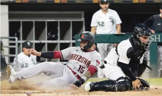  ?? DAVID BANKS/AP ?? The Diamondbac­ks’ Emmanuel Rivera is safe at the plate as catcher Carlos Perez snags a late throw during the fourth inning Saturday night.