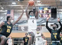  ?? VINCENT D. JOHNSON / DAILY SOUTHTOWN ?? Mount Carmel’s DeAndre Craig (4) finds an open lane to the basket between King’s Tahj McClearn, left, and DJ Jones on Tuesday during a game in Chicago.