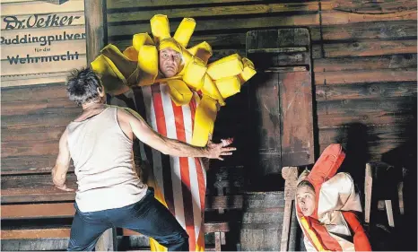  ?? FOTO: MATTHIAS HORN ?? Ähnlich banal sind eine Reihe von Zwischensz­enen: Eine Pommestüte (Josef Ostendorf) und ein Würstchen (Rocco Mylord) unterhalte­n sich über „die Großen der Geschichte“