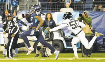  ?? Mark Zaleski / Associated Press ?? Tennessee running back Derrick Henry races for a touchdown as Jacksonvil­le linebacker Telvin Smith is chasing. Henry scored four times, once on a record-tying 99-yard run.