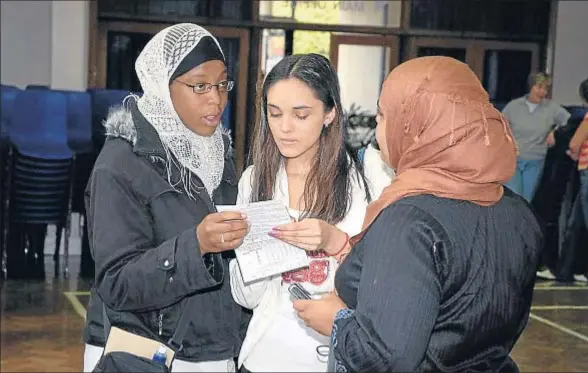  ?? PAUL BALDESARE. / GETTY ?? Jóvenes alumnas británicas comentan sus resultados del certificad­o general de educación secundaria